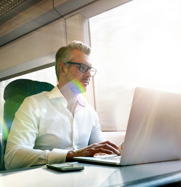 Business Man Working With His Lapton On a Train
