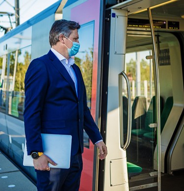 Business Man Getting On a Train Wearing a Mask