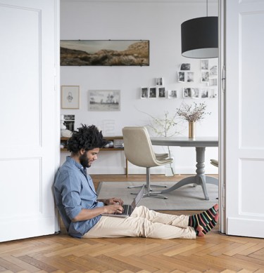 Man Sitting on Floor Working on Laptop