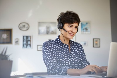 Woman Working On Laptop During COVID-19 With Headset