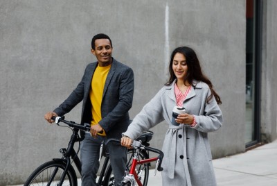 Man And Woman On Bikes With Reusable Cups