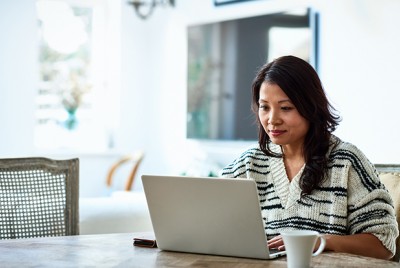 Woman smiling working at laptop